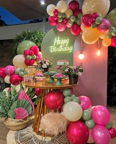 a table topped with lots of balloons and flowers