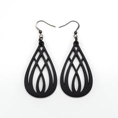 the black tear shaped earrings are made from wood and have an intricate cutout design