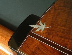 a close up of a wooden case with a leaf on the top and bottom part