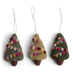 three small christmas trees hanging from strings