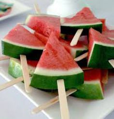 watermelon and lime popsicles are on a white plate with toothpicks