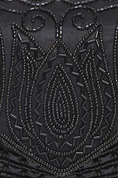 a black clutch bag with beading on the front and back side, featuring an intricate design