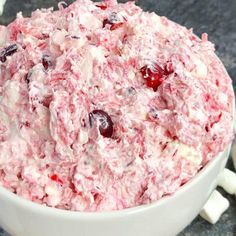 a white bowl filled with cranberry fluff and marshmallows on top of a table