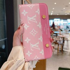 a woman holding up a pink and white case in front of her face while she is looking at the camera