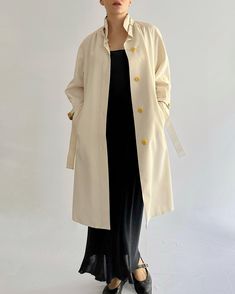 Vintage 1970s cream trench coat made in Spain, crafted from medium-weight polyester with subtle beige trim accents. This classic piece features a high-buttoned collar, adding structure and elegance, yellow buttons, a belted waist for a tailored fit, raglan sleeves and is fully lined. Simple, timeless design ideal for layering. CONDITIONS Excellent Conditions  DESCRIPTION Brand: Ginar Made in Spain Material: 100% Polyester Color: Cream, Beige Size: Fits best S-L (Can accommodate a range of sizes Classic Long Cream Outerwear, Retro Cream Outerwear For Spring, Cream Long Outerwear For Daywear, Vintage Beige Outerwear For Spring, Retro Beige Outerwear For Spring, Retro Beige Spring Outerwear, Vintage Beige Outerwear For Daywear, Retro Beige Long Coat, Vintage Beige Long Sleeve Outerwear