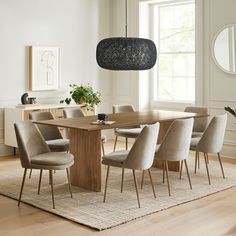 a dining room table with six chairs and a round light fixture hanging from the ceiling