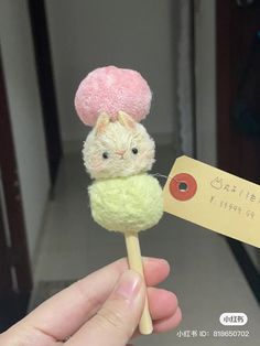 a person holding a small stuffed animal on a stick