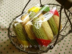 a basket filled with lots of green and yellow macaroons on top of a table