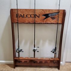 a wooden sign that says falcon on the front and back of fishing rods attached to it