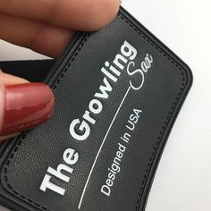 a woman's hand holding a black business card with the growing class on it