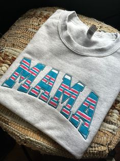 a t - shirt with the word mama printed in red, white and blue stripes