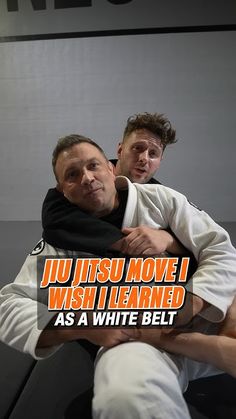 two men are hugging each other while one is wearing a black scarf and the other has a white belt