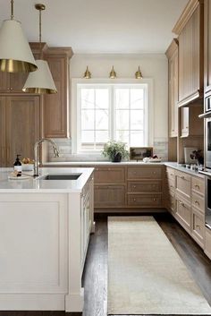 a large kitchen with wooden cabinets and white counter tops, along with an area rug on the floor