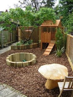 a wooden bench sitting in the middle of a garden next to a small fire pit