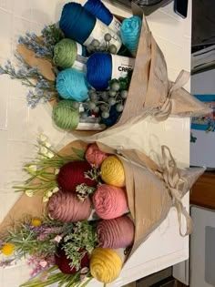 two bags filled with yarn sitting on top of a kitchen counter next to each other