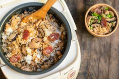 a bowl filled with rice and mushrooms next to a wooden spoon on top of a table