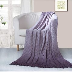 a white chair with a purple blanket on it