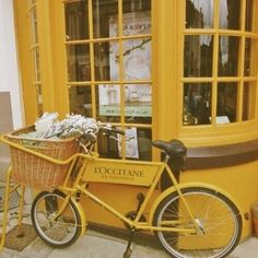 a yellow bicycle parked in front of a store