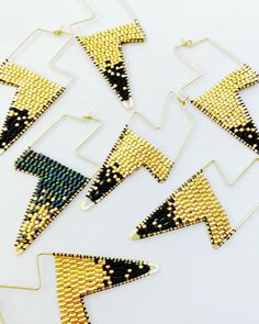 Raw brass lightning bolt shaped hoops filled gold and black Japanese glass beads. The beads are woven in an ombré pattern.   26mm x 60mm Bolt Earrings, Beaded Charms, Black Japanese, Lightning Bolt Earrings, Triangle Studs, Lightning Bolt, Fun Earrings, Jewelry Earrings Hoops, Raw Brass