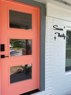 an orange door with the words seven thirty painted on it's side and windows