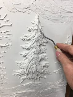 someone is using a brush to paint a white tree