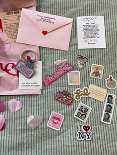 a table topped with lots of different types of magnets and paper crafts on top of a bed