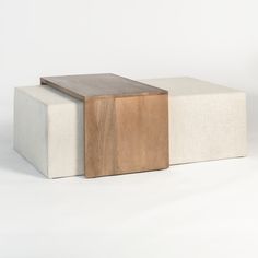 three different colored stools sitting next to each other on a white surface and one is made out of wood