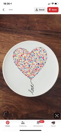 a heart shaped plate with confetti on it and the word love spelled in cursive writing