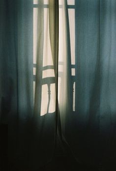 the shadow of a curtain on a window