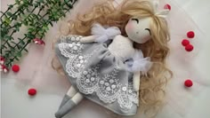 a doll with blonde hair laying on top of a pillow