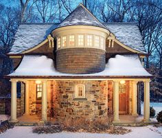 a stone house with snow on the ground and trees in the backgrouds