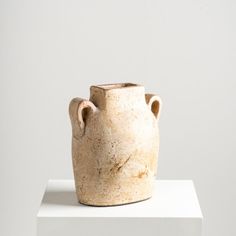 a vase sitting on top of a white pedestal