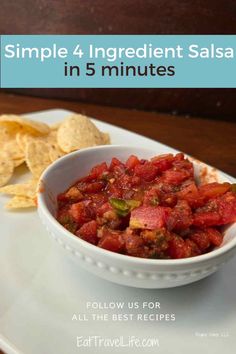 a white bowl filled with salsa and tortilla chips on top of a plate