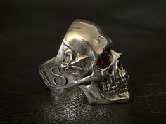 RING PROFILE: 🔱Our Mortis Motif Bloodshot silver skull ring is certainly one of the most anatomically accurate and detailed skull rings on the market. We have put a lot passion and attention to detail to create a skull full of character and personality. We've aimed for a rather aged and subtly sad-looking expression which represents the experience and burden of a human life. �🔱To make this skull ring an even more extraordinary piece we have attached a Fleur-de-Lis on each side of the temple and Skull Rings, Exotic Jewelry, Silver Skull Ring, Tarnish Remover, A Skull, Armors, Bespoke Jewellery, Baby Oil, Skull Ring