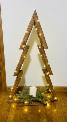 a christmas tree made out of wooden planks with lights on the top and bottom