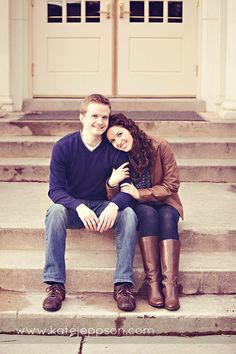 a man and woman sitting on steps in front of a door with their arms around each other