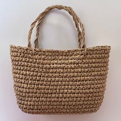 a large woven straw bag on a white background with the handle extended to show it's inner lining