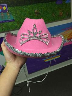 a pink hat with silver sequins on the crown is being held by a person