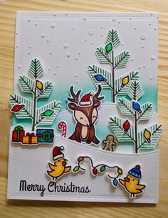 a christmas card with an image of a deer and birds in the background, on a wooden table