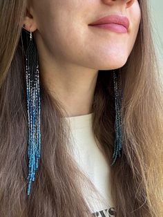 a close up of a person wearing some kind of blue beaded earring on their head