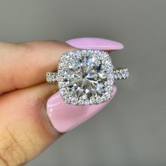 a close up of a person holding a ring with a diamond on it's middle finger