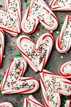 some very pretty decorated cookies with candy canes on it's sides and sprinkles all over them