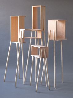 four wooden chairs are lined up in the shape of squares and rectangles, with one sitting on top of another