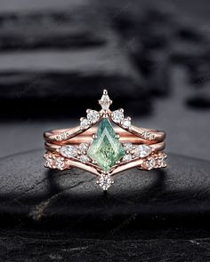 an engagement ring with a green stone surrounded by diamonds