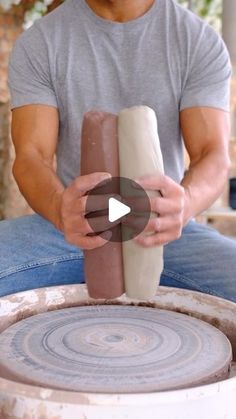 a man is sitting on the ground making something out of clay