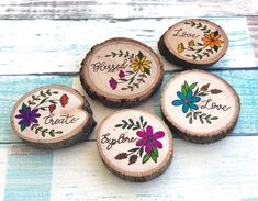 four wooden coasters with painted flowers and the words love, hope, and god on them