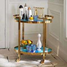 a gold bar cart with bottles and glasses on it