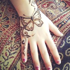 a woman's hand with a butterfly tattoo on it