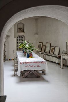 an archway leading into a dining room with a table covered in a white tablecloth