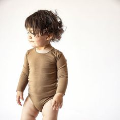 This soft, stretchy and breathable onesie comes with a rounded neck, press buttons on the shoulder and crafted from Bacabuche's snuggly organic cotton solids. Notice Bacabuche's favorite details, which are the unique edge stitching on the collar and at the wrist and the sweet embroidered logo. | Bacabuche | Baby Jersey Onesie, Camel | Organic Cotton (Brown, Size 6-12M)  |  Maisonette collects the best children’s products from around the world (unlike Zulily, Etsy, The Tot, Farfetch Kids, Childre Fitted Bodysuit For Playtime, Solid Color Long Sleeve Bodysuit For Playwear, Long Sleeve Bodysuit For Playwear, Beige Long Sleeve Onesie For Playtime, Edge Stitching, Edge Stitch, The Sweet, Snug Fit, Baby Toddler